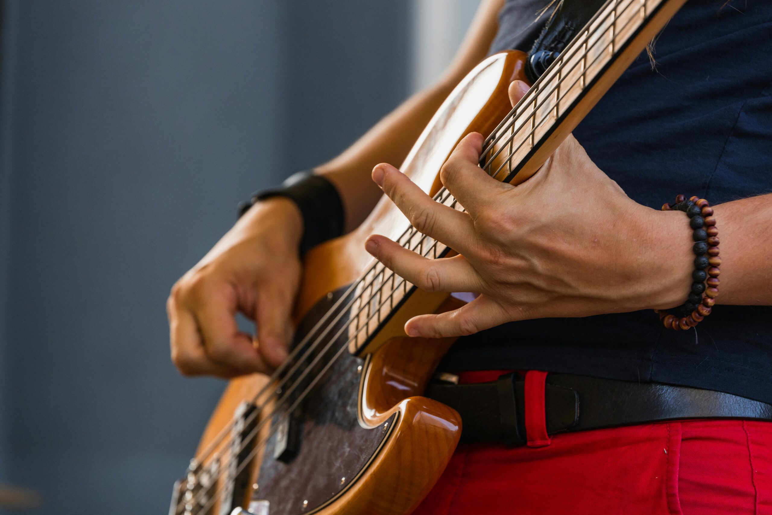 A musician plays the bass guitar passionately during an outdoor performance.